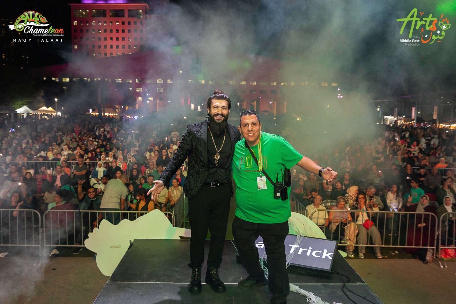 Magician posing with a crew member on stage after the finale