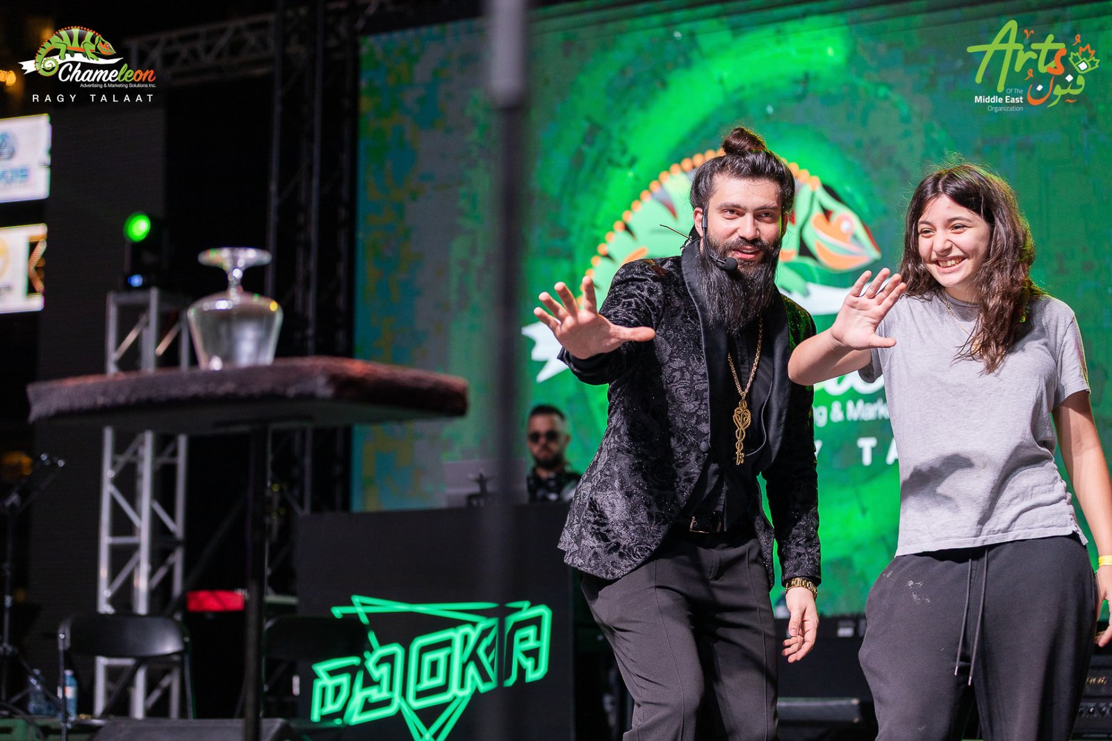 Magician performing on stage with a volunteer from the audience