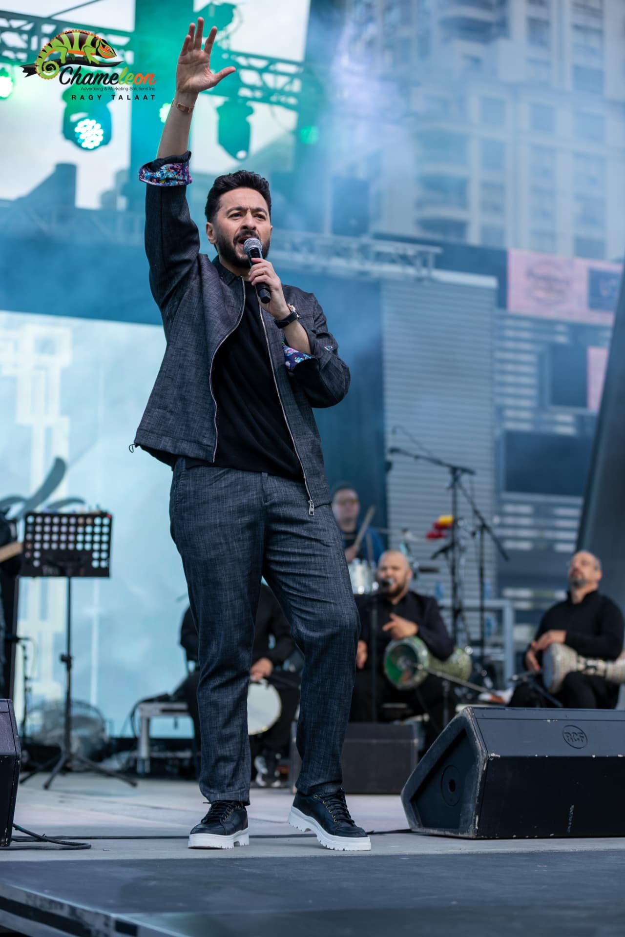 Hamada Helal with one arm raised while singing — photo 27